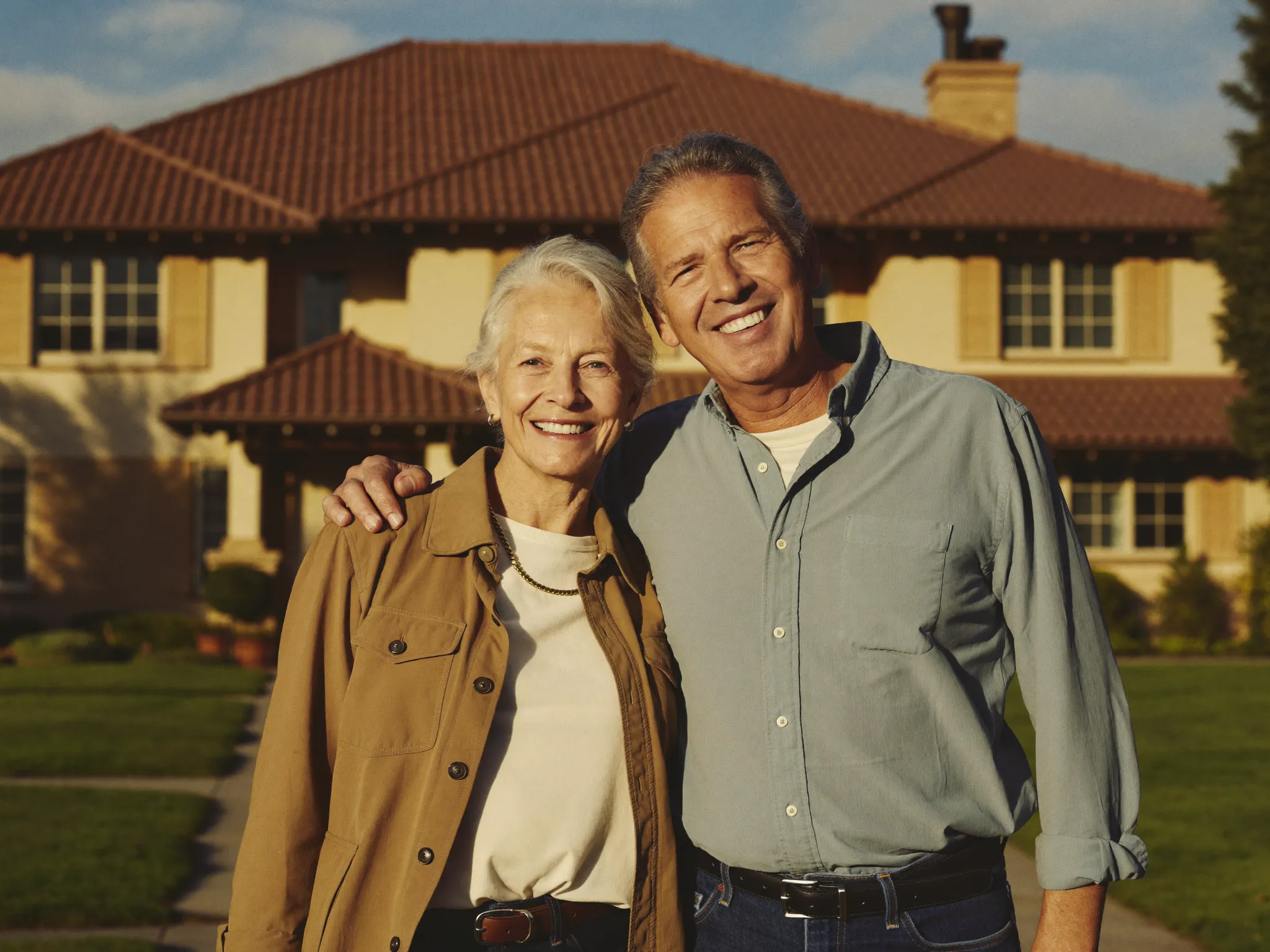 Homeowners in front of their house after a roof assessment